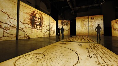 Walking through da Vinci’s mind—iconic sketches come alive in a breathtaking immersive experience. Visitors explore towering projections of Leonardo da Vinci’s sketches in an immersive gallery space.