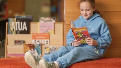 child reading a book in the library