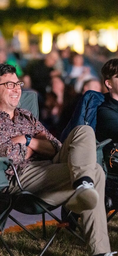 Crowd looking on, watching film festival in outdoor venue