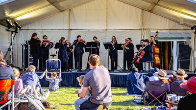 A father and child kneel to watch CSO perform at Live at Lanyon