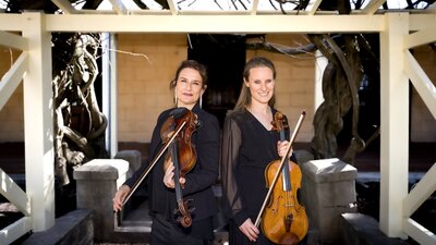 CSO musicians Kirsten Williams and Lucy Carrigy-Ryan posing holding their instruments at Lanyon.