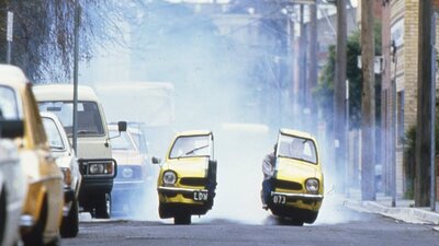 Yellow car split in half driving down a street
