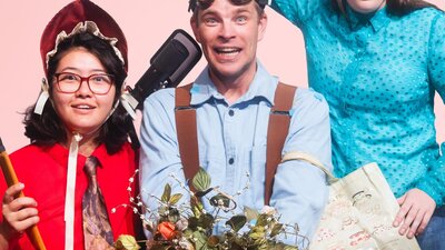 3 people holding garden items looking at something coming towards them with anticipation