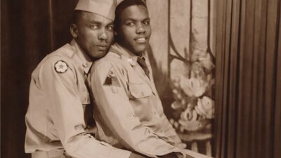 Archival image of two military men embracing in a pose looking at camera