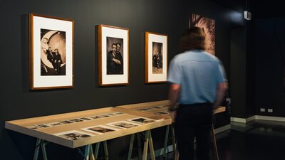 Man observing photographic display in LOVING at CMAG