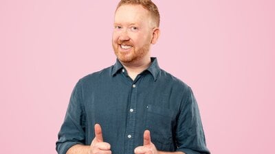 Man with red hair giving a double thumbs up and smiling