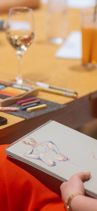 Person wearing colourful clothing drawing