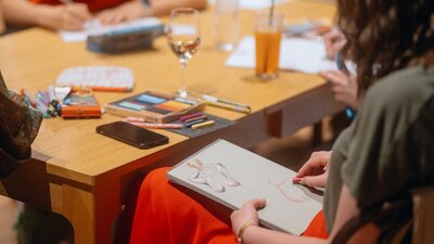 Person wearing colourful clothing drawing