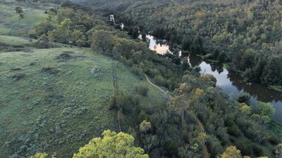 an arial photo of bushland and a river