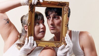 Two mime artists holding a picture frame