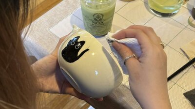 Guest hand-painting a ceramic cup at a NOA Matcha workshop