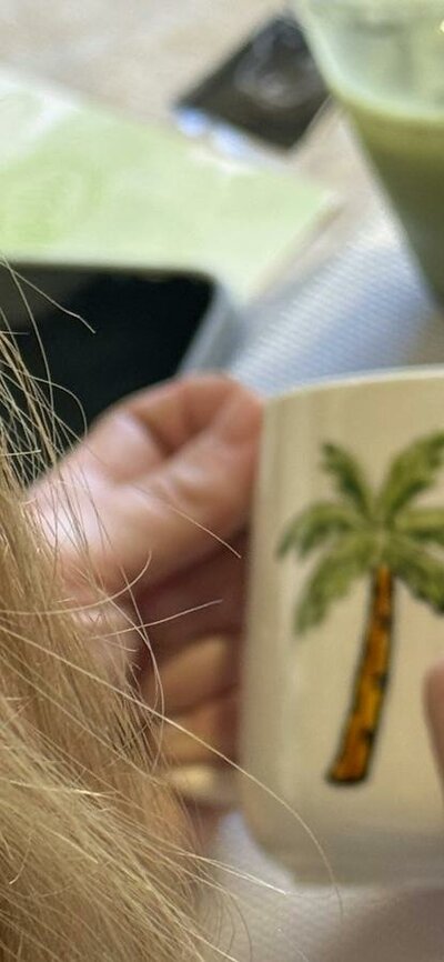 Guest hand-painting a ceramic cup at a NOA Matcha workshop