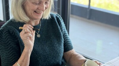 Guest hand-painting a ceramic cup at a NOA Matcha workshop