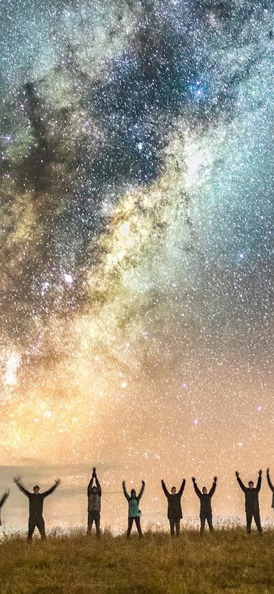 Astrophotographers posing under the Milky Way