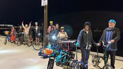 Guests on a bike party line up on the boardwalk beside Lake Burley Griffin.