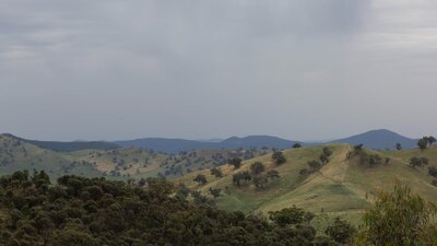 view of green hills with dark blue sky
