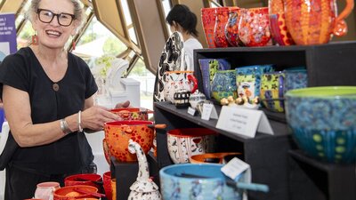 Photo of a market vendor with her ceramics inside the Museums Gandel Atrium