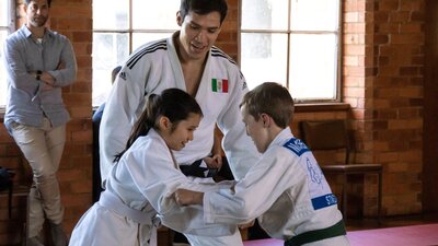 Eduardo Avila Sanchez (NICO) coaching  Nia Rush (ISABELLA) in judo with SAM watching
