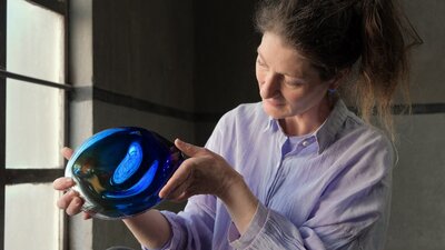 Designer with blue glass object