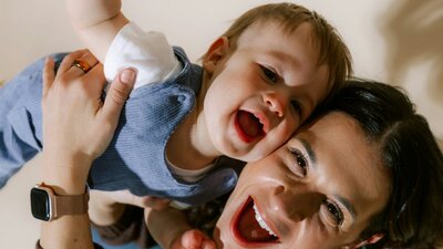 Laughing mother holding laughing baby