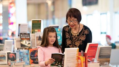 A woman and young girl looking at books in the National Library of Australia Bookshop