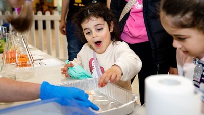 A young girl shows excitement over a checmistry science experiment