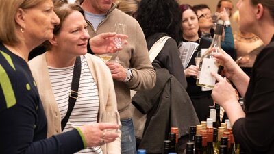 People listening to a steward talk about the wine they are about to taste. Wine Tasting