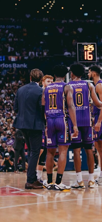 Players gather midcourt during a Sydney Kings game