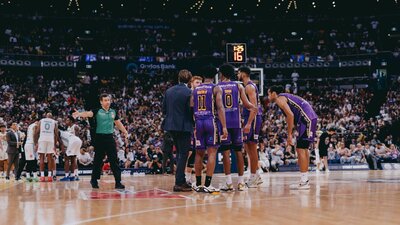 Players gather midcourt during a Sydney Kings game