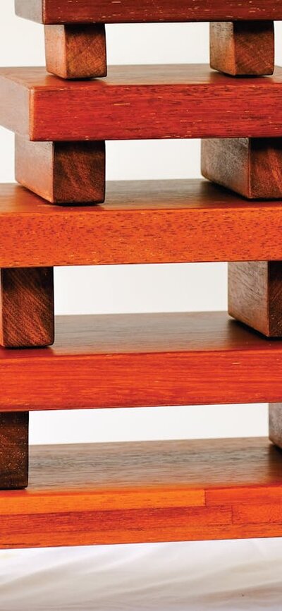 Five small red wooden tables stacked on top of each other