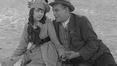 NFSA Restores: The Sentimental Bloke Black and white still of a woman and man sitting next to each other acting coy