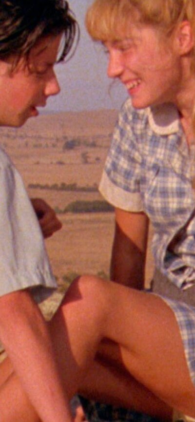 NFSA Restores: The Year My Voice Broke (1987) Young couple facing each other smiling with Australian landscape in background