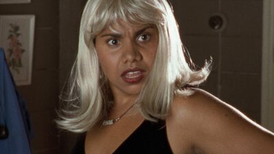 NFSA Restores: Radiance Woman looks surprised wearing a blonde wig and red lipstick