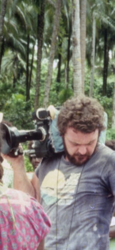 Tukana (1982) One cameraman stands looking in his pocket, other actors standing around