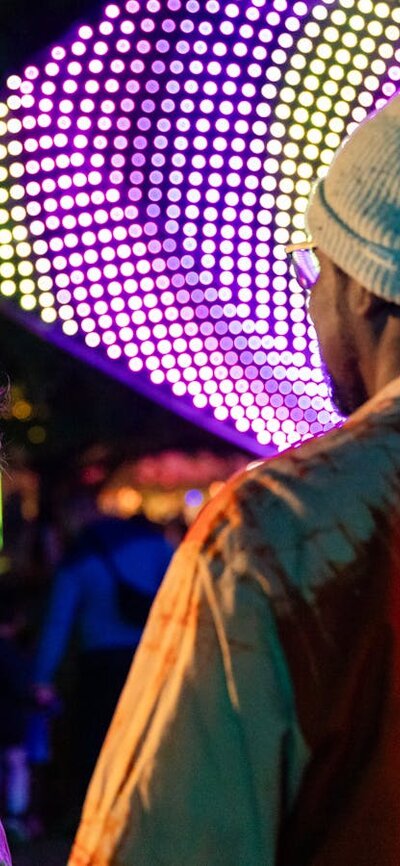 Two people smiling, enjoying entertainment at NightFest