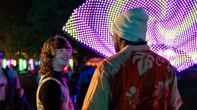 Two people smiling, enjoying entertainment at NightFest