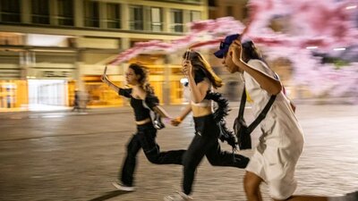 Night Walks with Teenagers Bologna 2023 three teenagers running at night with pink flares