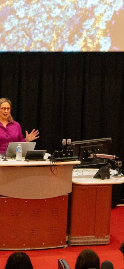 Professor Misty Jenkins giving a lecture at a podium in a lecture theatre
