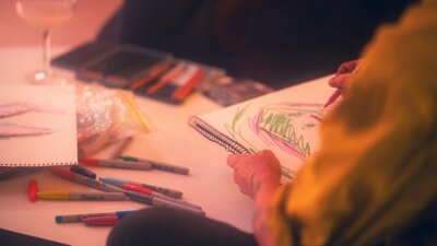 Person wearing hi-vis drawing using textas