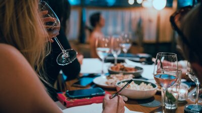 Woman drinking sparkling wine with art model sitting in background