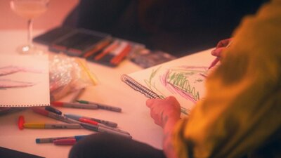 Person wearing hi-vis drawing using textas