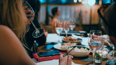 Woman drinking sparkling wine with art model sitting in background