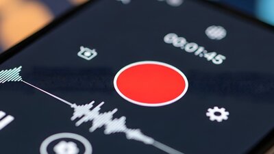Close-up of a smartphone screen displaying a media player interface with a prominent record button.