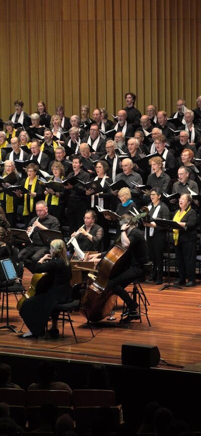 Erin Helyard conducting from harpsichord, orchestra playing and choir singing