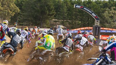 A pack of riders round a corner into the Holeshot gate
