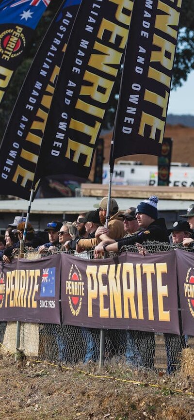 Spectators lined up along the fence viewing the racing action