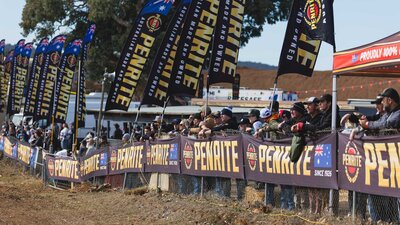 Spectators lined up along the fence viewing the racing action