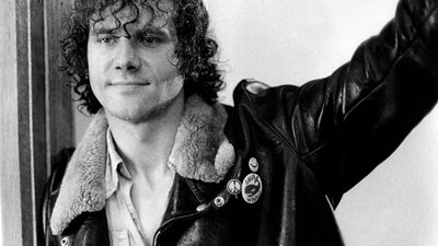 The Plumber ( 1979 | PG ) Black and white image of man with curly hair smiling