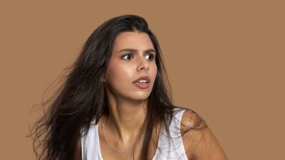 Picnic at Hanging Rock Young woman in white dress looks scared off camera