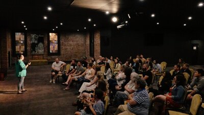 Scientist presenting their research to an audience, at Adelaide Pint AU event.
